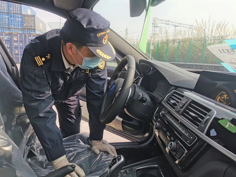 海关工作人员对进口汽车进行口岸检验检疫
